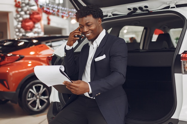 Hombre guapo y elegante en un salón del automóvil