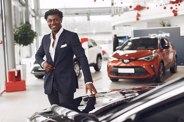 Hombre guapo y elegante en un salón del automóvil