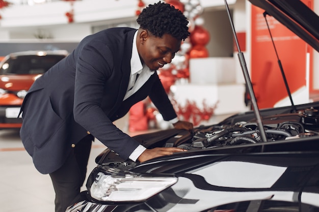 Hombre guapo y elegante en un salón del automóvil