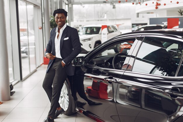 Hombre guapo y elegante en un salón del automóvil