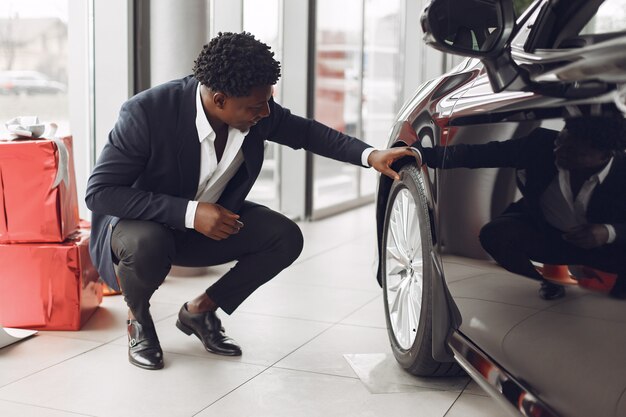 Hombre guapo y elegante en un salón del automóvil