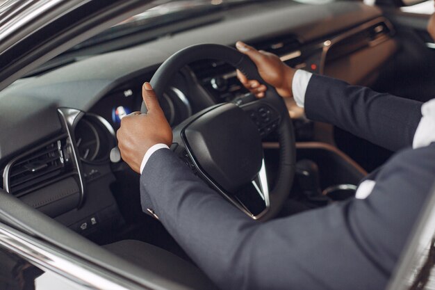 Hombre guapo y elegante en un salón del automóvil