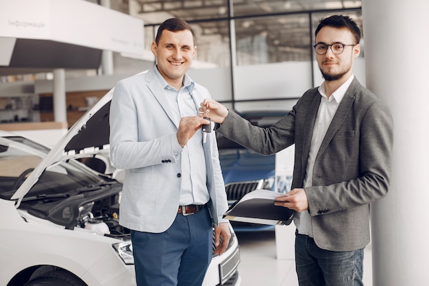 Foto gratuita hombre guapo y elegante en un salón de autos.