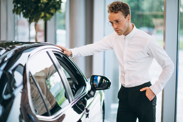 Hombre guapo eligiendo un coche en una sala de espectáculos