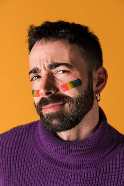 Hombre guapo emocional con simbolo LGBT en cara