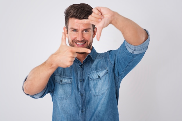 Foto gratuita hombre guapo enmarcando su rostro