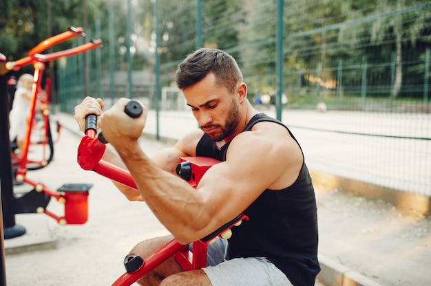 Hombre guapo entrenando en un parque de verano