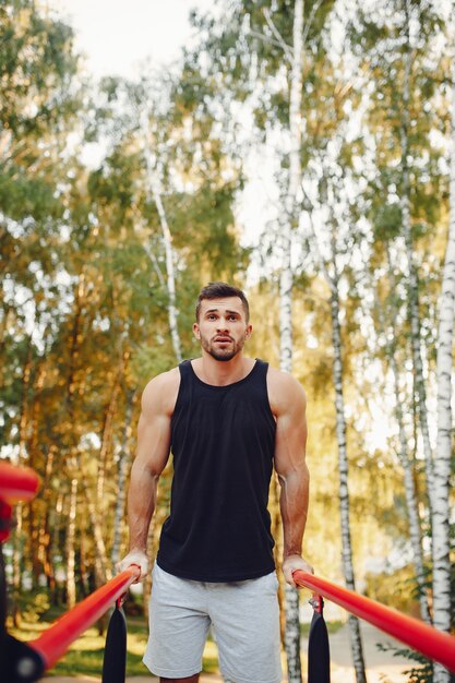 Hombre guapo entrenando en un parque de verano