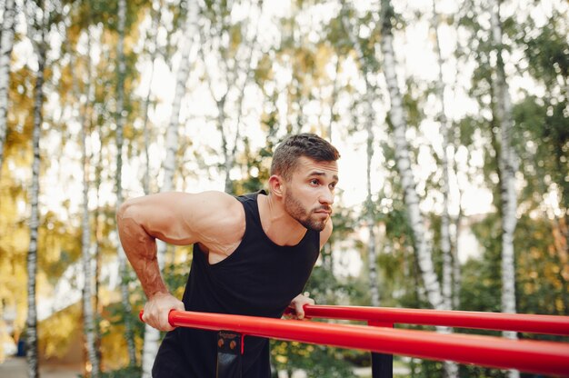 Hombre guapo entrenando en un parque de verano