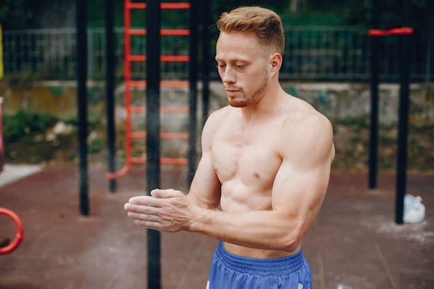 Hombre guapo entrenando en un parque de verano