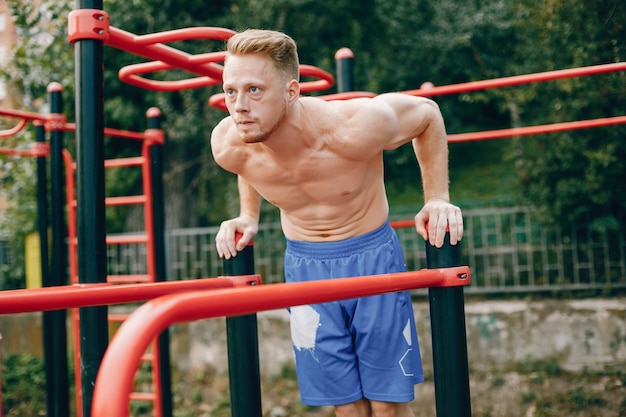 Hombre guapo entrenando en un parque de verano