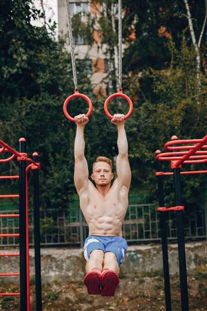 Hombre guapo entrenando en un parque de verano