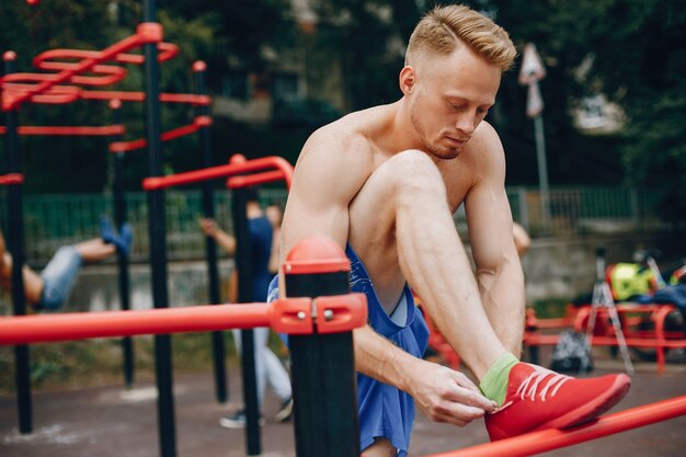 Hombre guapo entrenando en un parque de verano