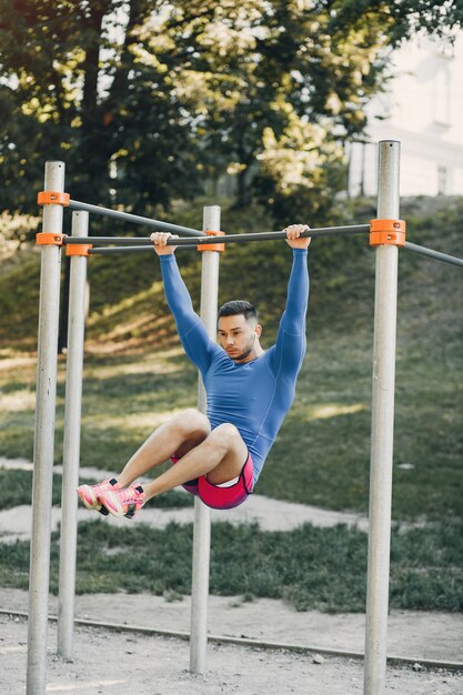 Hombre guapo entrenando en un parque de verano