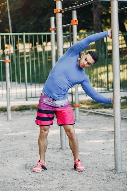 Hombre guapo entrenando en un parque de verano