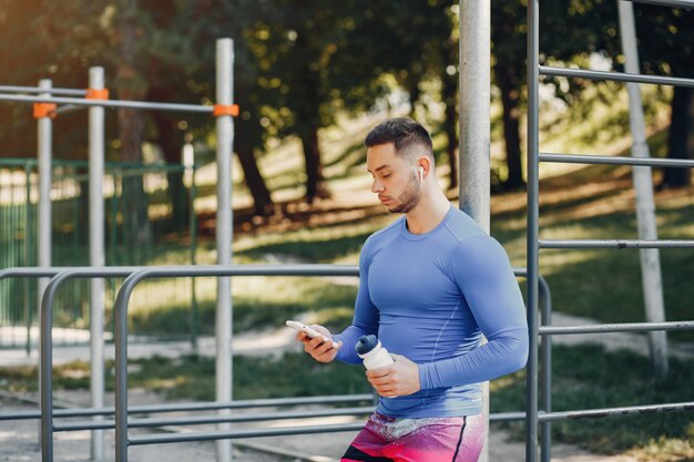 Hombre guapo entrenando en un parque de verano