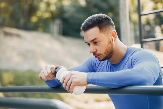 Hombre guapo entrenando en un parque de verano