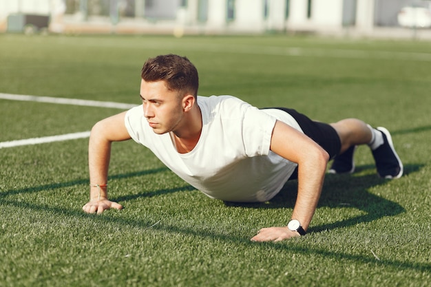 Hombre guapo entrenando en un parque de verano