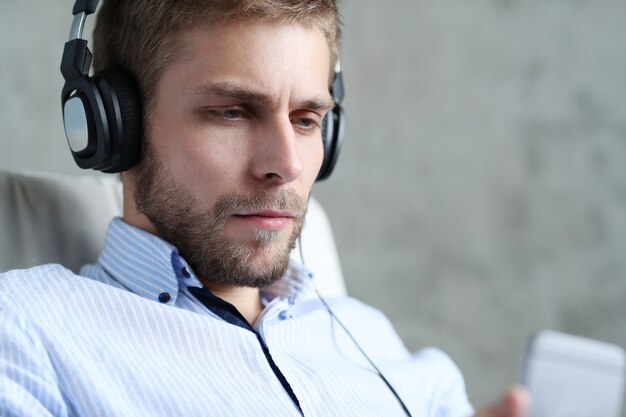 Hombre guapo escuchando música con auriculares