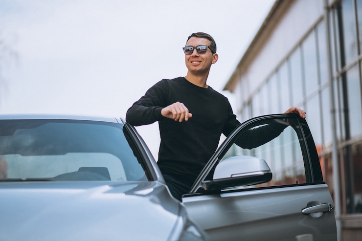 Foto gratuito hombre guapo exitoso por el coche