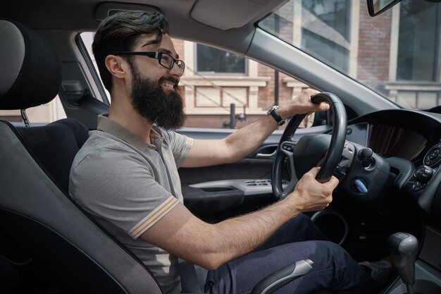 Hombre guapo y feliz conduciendo el coche