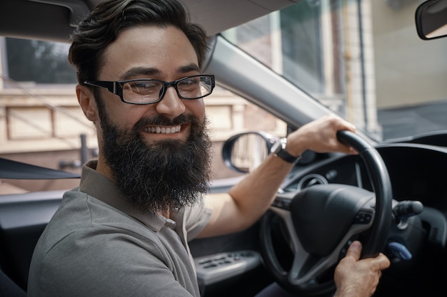 Hombre guapo y feliz conduciendo el coche