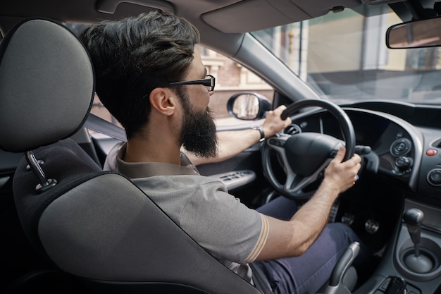 Hombre guapo y feliz conduciendo el coche