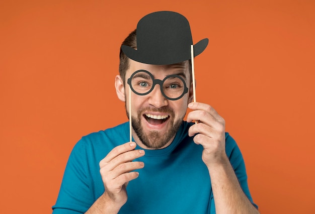 Hombre guapo feliz posando con gafas falsas