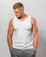 Foto gratuita hombre guapo en forma posando mientras usa camiseta sin mangas
