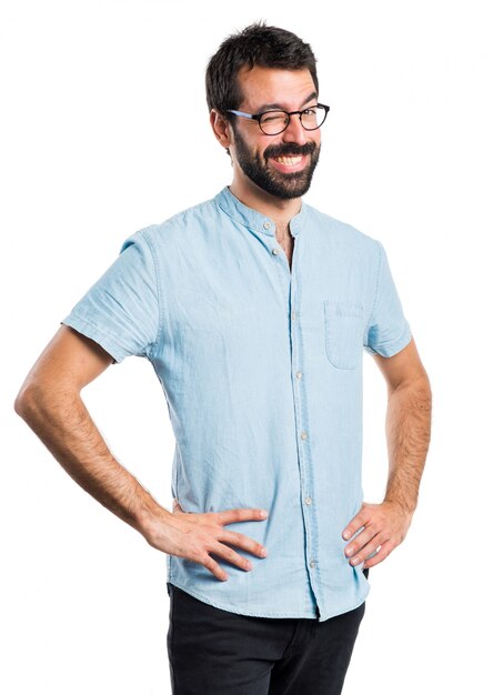 Hombre guapo con gafas azules guiñando