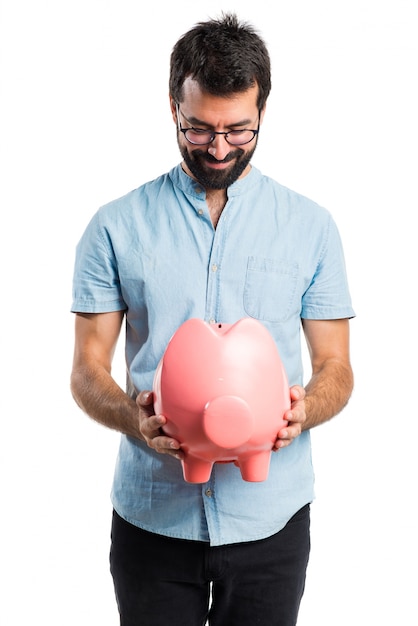 Hombre guapo con gafas azules con un piggybank