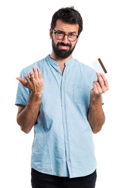 Hombre guapo con gafas azules con una tarjeta de crédito