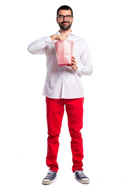 Hombre guapo con gafas comiendo palomitas