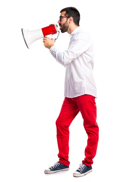 Hombre guapo con gafas gritando por megáfono