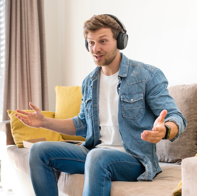 Hombre guapo grabando a sí mismo con auriculares en