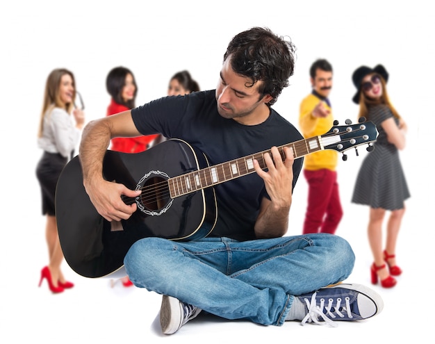 Hombre guapo con la guitarra sobre fondo blanco