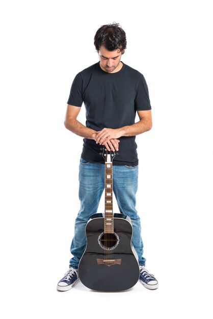 Hombre guapo con la guitarra sobre fondo blanco