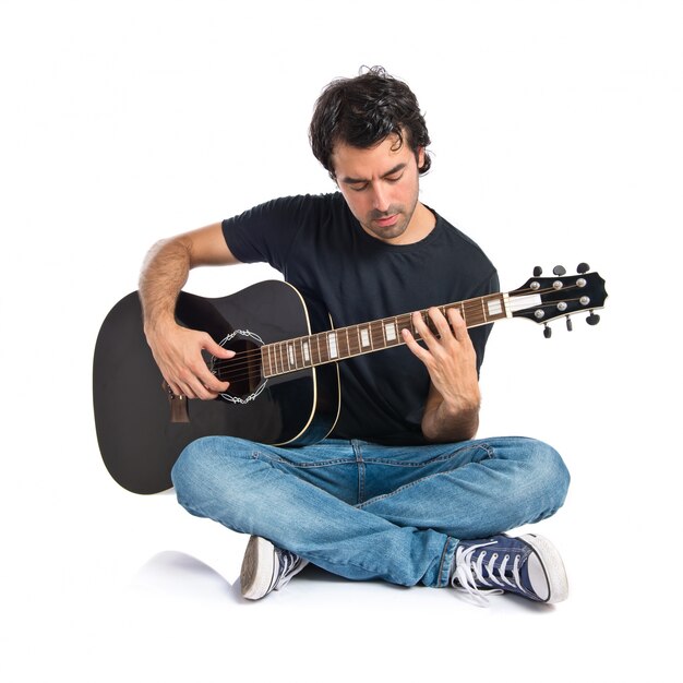 Hombre guapo con la guitarra sobre fondo blanco