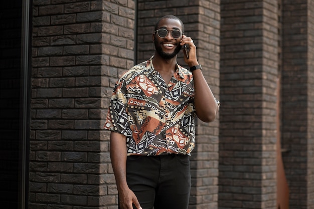 Foto gratuita hombre guapo hablando por teléfono al aire libre