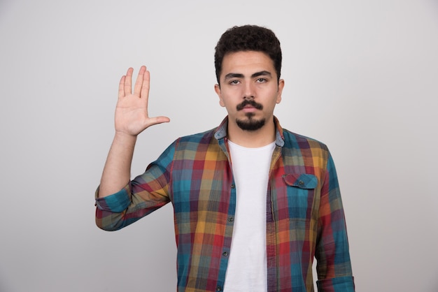 Hombre guapo joven con barba haciendo gesto de parada.