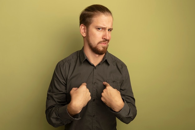 Hombre guapo joven en camisa gris disgustado apuntando a sí mismo