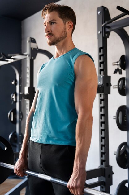 Hombre guapo joven entrenando en el gimnasio para culturismo