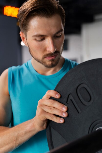 Hombre guapo joven entrenando en el gimnasio para culturismo