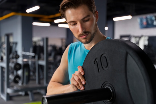 Hombre guapo joven entrenando en el gimnasio para culturismo