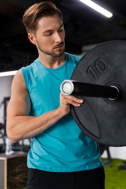 Foto gratuita hombre guapo joven entrenando en el gimnasio para culturismo