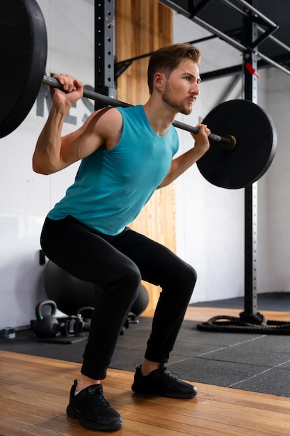 Hombre guapo joven entrenando en el gimnasio para culturismo