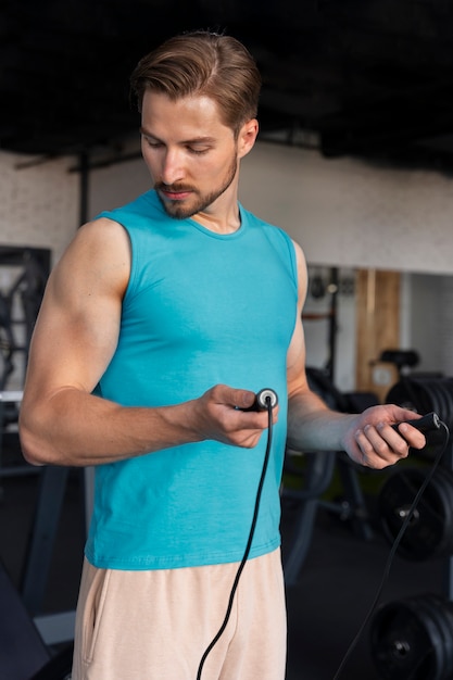 Hombre guapo joven entrenando en el gimnasio para culturismo