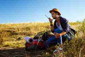 Foto gratuita hombre guapo joven hablando por radio walkie talkie, disfrutando de la vista del cañón