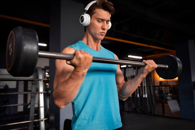 Hombre guapo joven haciendo ejercicio en el gimnasio para culturismo