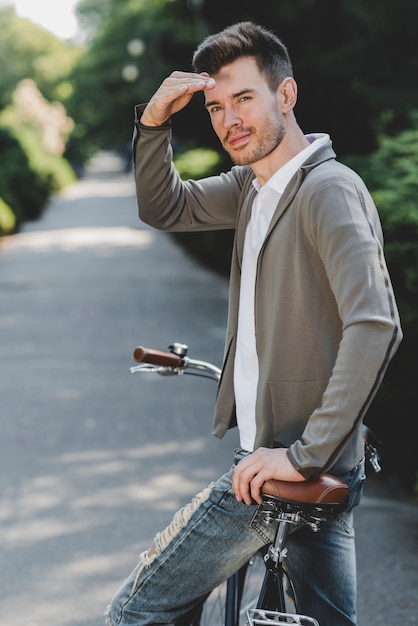 Foto gratuita hombre guapo joven en ojo de blindaje de bicicleta